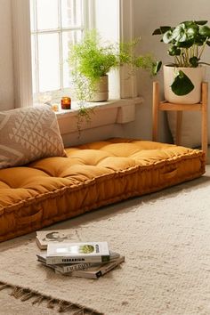 a living room filled with furniture and a book on the floor next to a window