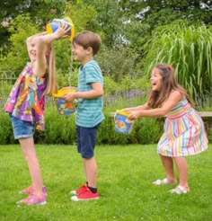 three young children playing in the grass