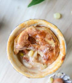 an overhead view of a dessert in a glass on a table with nuts and leaves