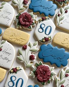 decorated cookies with flowers and the number eighty on them are displayed for someone's 80th birthday