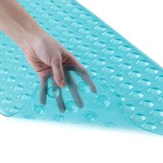 a person's hand on top of a blue mat with water drops around it