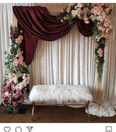 a white bench sitting next to a window covered in flowers and greenery on top of a carpeted floor