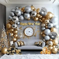 a living room decorated for new year's eve with gold and silver balloons, presents, and a large clock