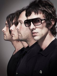 three men in black shirts and sunglasses are looking at the same person's face