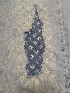 an old pair of jeans that has been stitched together with white flowers on them