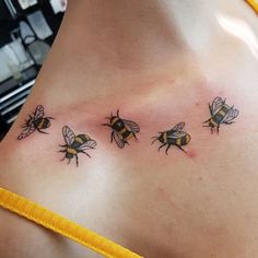 three bums on the back of a woman's chest, one is yellow and two are black