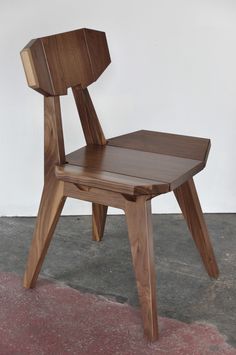 a wooden chair sitting on top of a cement floor