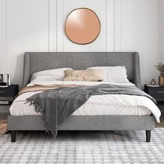 a bedroom with a bed, nightstands and a round mirror on the wall