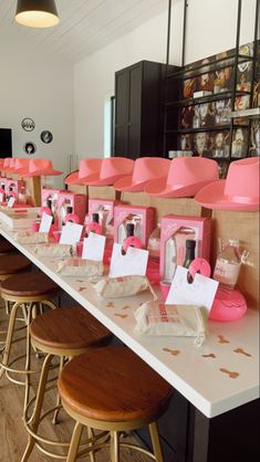 a long table with pink chairs and place cards on the tables in front of them