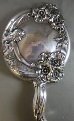 an ornate silver spoon with flowers on it