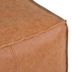 a brown leather ottoman with stitching on it