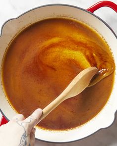 a wooden spoon is being used to stir soup