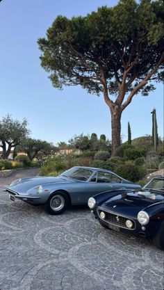 two classic sports cars parked next to each other