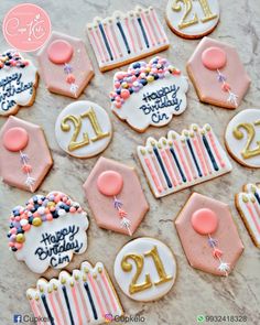 decorated cookies with candles and decorations for a 21st birthday party on a marble countertop