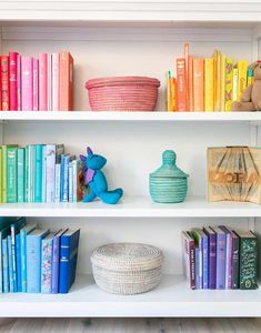 the bookshelves are filled with many different colored books and baskets on top of them