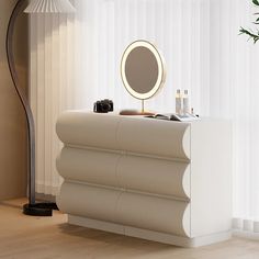 a white dresser with a mirror and cosmetics on it