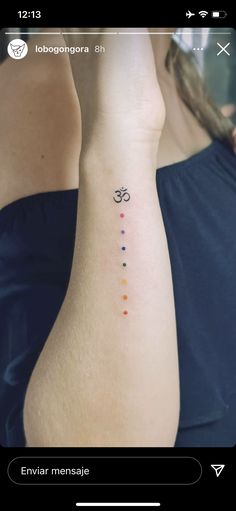 a woman's arm with a tattoo on it that has an omen symbol