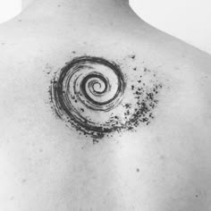 a black and white photo of a man's back with a spiral tattoo on it