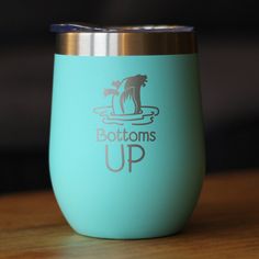 a close up of a cup on a wooden table with the bottom half painted blue