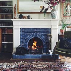 a living room filled with furniture and a fire place in front of a book shelf