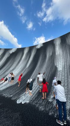 several people standing in front of a giant wave