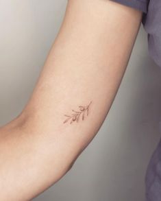 a woman's arm with a small tattoo on the left side of her arm