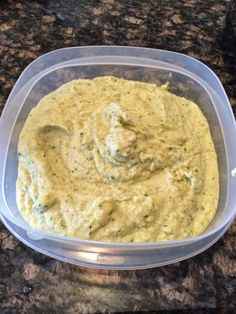 a plastic container filled with hummus sitting on top of a counter