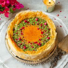 a cake on a plate with flowers and candles in the background