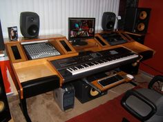 there are many musical instruments on the desk in front of the sound board and speakers