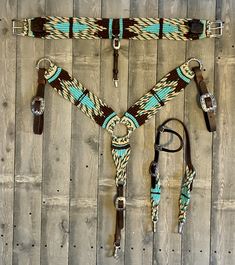 a horse bridle with matching reins and halters on a wooden floor in front of a wall