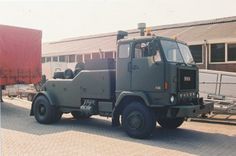 an army truck parked in front of a building