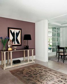 a living room filled with furniture and a painting on the wall next to a table