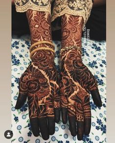 two hands that are decorated with henna and bracelets on top of each other