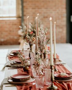 the table is set with candles and plates