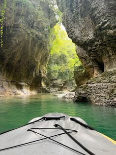 there is a boat that is going through the water in the river and it's rocks