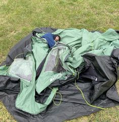 an outdoor sleeping bag is on the ground with its hood up and head in it's pocket