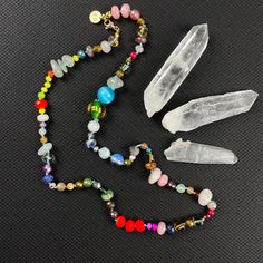 Dive into a kaleidoscope of color with our handcrafted Crystal Confetti Bead Necklace, a statement piece that promises to be as unique as you are. Each bead is lovingly hand-knotted, creating a flow of hues and textures that dance along a durable, colorful nylon cord. 🌟 Highlights:     Hand-knotted for durability and unique design     A vibrant mix of gemstones, glass, wood, ceramic, and resin beads     Bead sizes vary from 2-14mm for a dynamic visual texture     Approximately 21.5 inches in length, perfect for layering or as a standalone statement     Finished with lustrous gold plated stainless steel findings     Receive the exact necklace pictured in the photos 📏 Length: This enchanting necklace measures approximately 21.5 inches, a versatile length that complements both high and low Adjustable Rainbow Crystal Necklace With Faceted Beads, Rainbow Faceted Beads Necklace For Gift, Colorful Faceted Beads Jewelry For Festivals, Beaded Crystal Necklaces With Round Beads For Festivals, Rainbow Beaded Necklace With Gemstone Beads For Gift, Bohemian Iridescent Round Bead Jewelry, Rainbow Beaded Necklaces With Gemstone Beads As Gift, Rainbow Gemstone Beaded Necklaces As A Gift, Rainbow Crystal Necklaces With Round Beads Gift