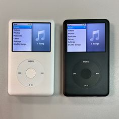 two mp3 players sitting side by side on top of a white table next to each other