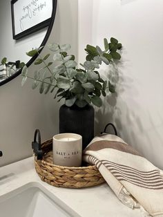 a bathroom sink with a basket and towel on it, next to a mirror that says salt and pepper