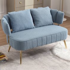 a blue couch sitting on top of a white rug