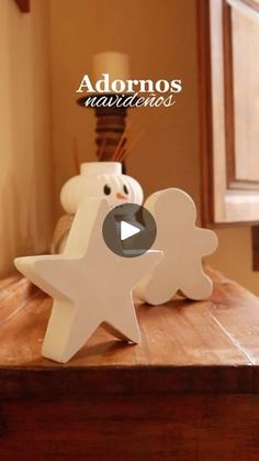 two white stars sitting on top of a wooden table next to a lamp and window