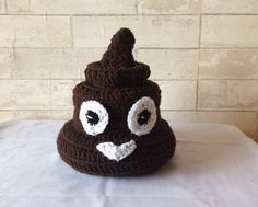 a brown crocheted poop hat with eyes and nose on white table cloth