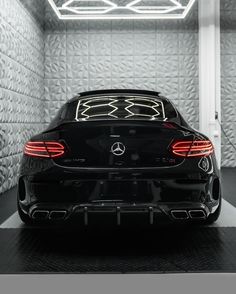 the back end of a black car in a garage