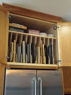 an open cabinet filled with lots of dishes and utensils on top of each other