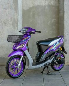 a purple and silver scooter parked next to a wall