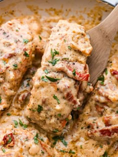 a pan filled with meat covered in sauce and garnished with parsley