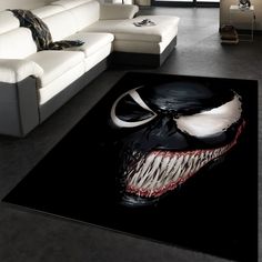 a living room with a couch, rug and painting on the floor in front of it