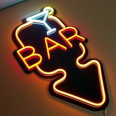 a neon sign that says bar with a martini glass on it's back side