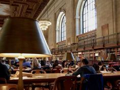 people are sitting at tables in the library