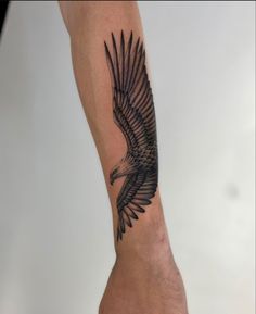 a black and white eagle tattoo on the arm